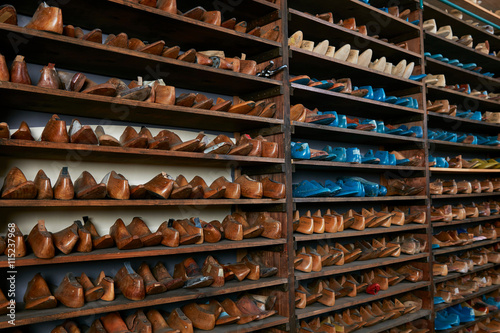 Rows of old wooden shoe lasts on shelves in traditional shoe shop