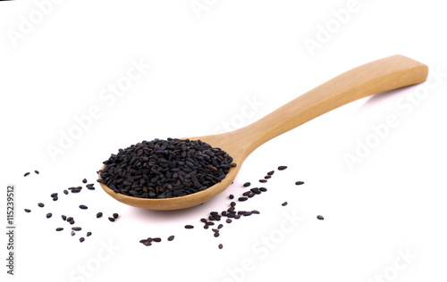 Heap of black sesame on wooden spoon on white background