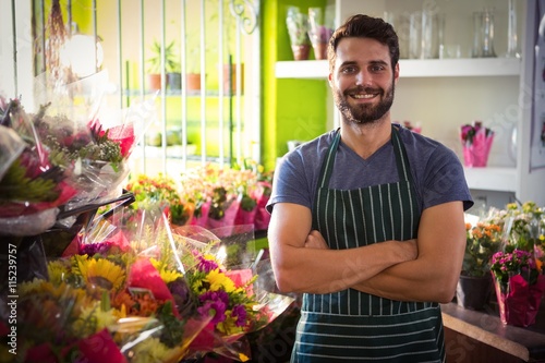 Male florist with arms crossed at his flower shop