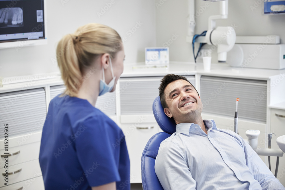 happy female dentist with man patient at clinic happy female dentist with man patient at clinic