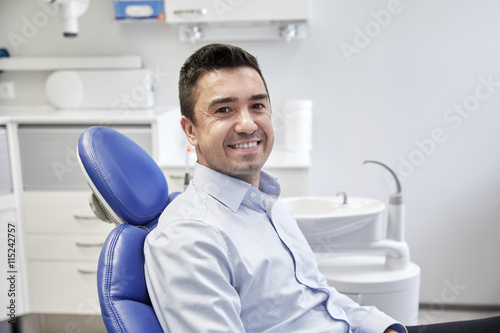 happy male patient sitting on dental chair