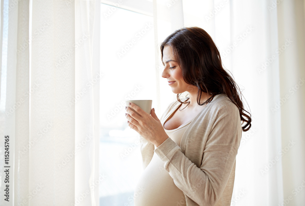 happy pregnant woman with cup drinking tea at home happy pregnant woman with cup drinking tea at home