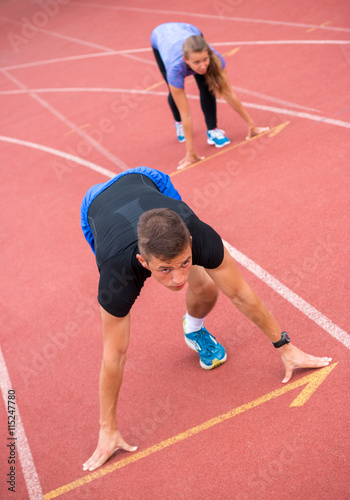 Young athlete on a running track, ready to go from starting blocks