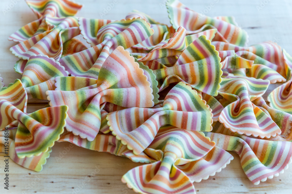 Close up of a dried fresh multicolored pasta on wooden background Close up of a dried fresh multicolored pasta on wooden background