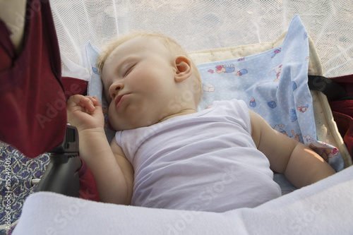 Малыш спит в коляске на природе