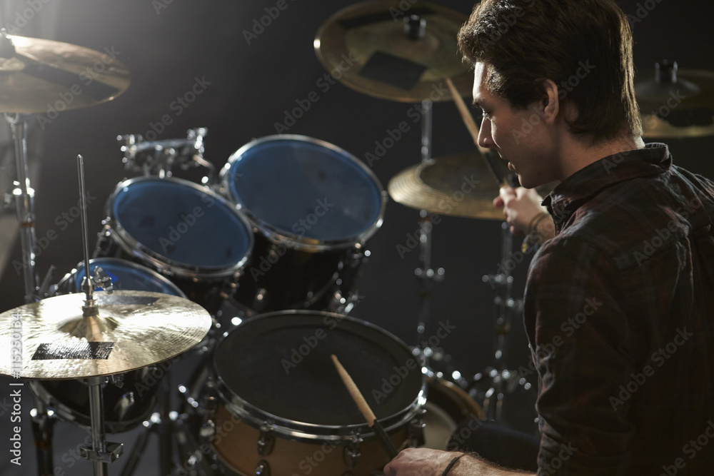 Fototapeta premium Rear View Of Drummer Playing Drum Kit In Studio