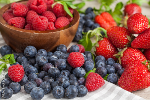 fresh raspberries  blueberries and strawberries on wooden background