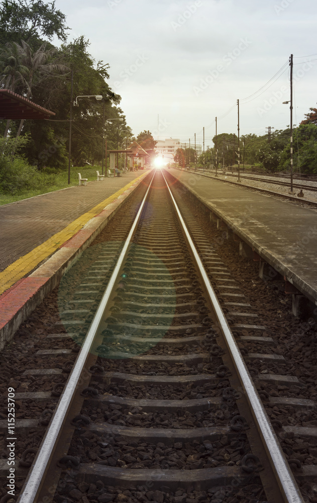 Obraz premium view of the length of railway with pavement at left and right side of railway,filtered image, light effect and flare added,selective focus,mean 
