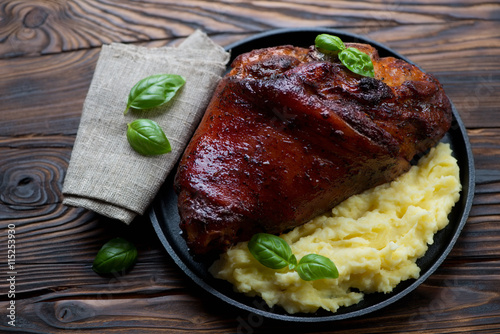 Frying pan with roasted pork knuckle and mashed potato
