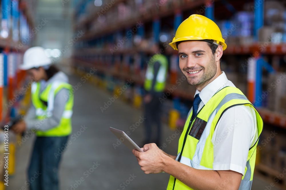 Worker in warehouse looking at camera Worker in warehouse looking at camera