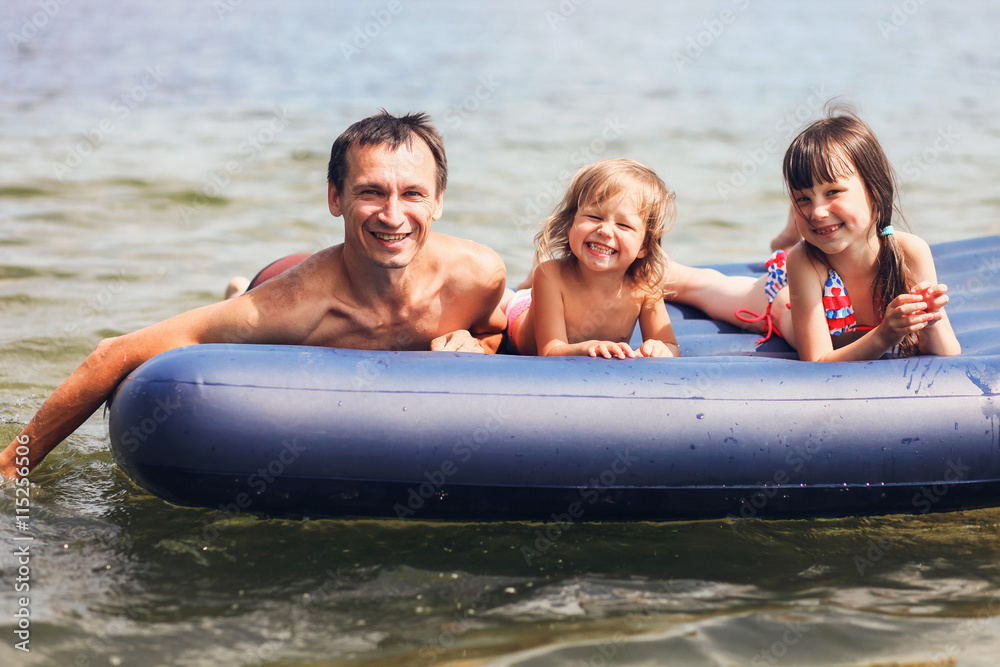 Obraz premium Family floating on mattresses.