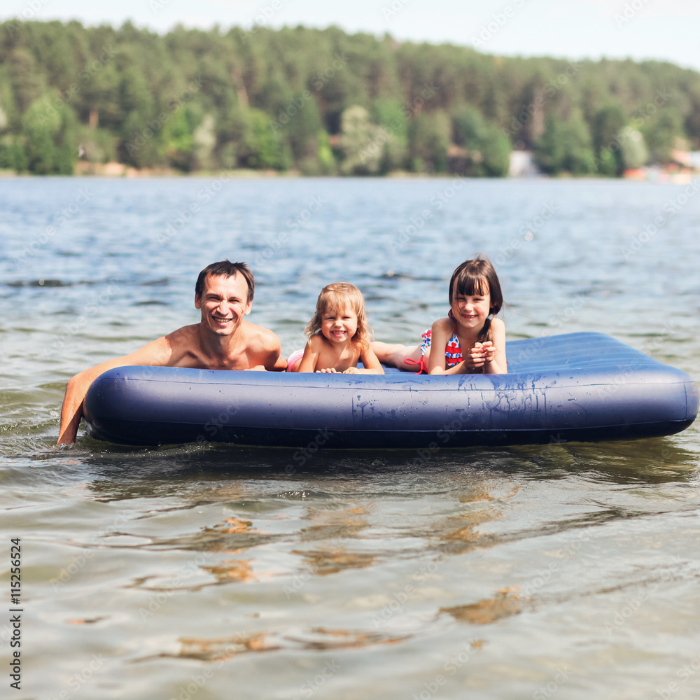 Obraz premium Family floating on mattresses.
