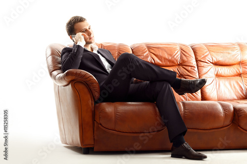 Businessman talking phone .sitting on the couch