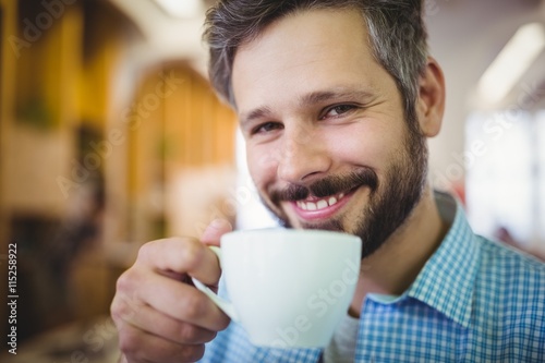 Happy businessman having coffee at office cafeteria