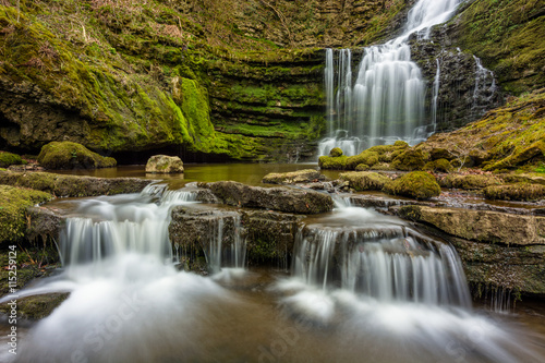 Beautiful woodland flowing waterfall with small cascades in North Yorkshire  UK.