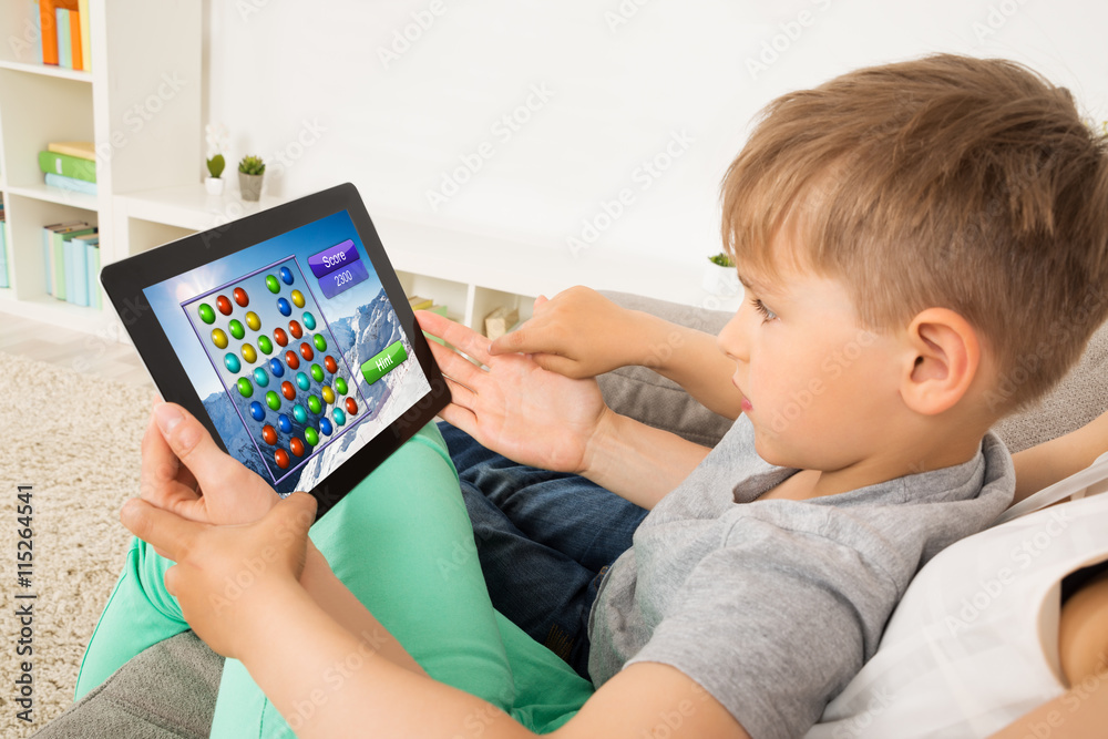 Little Child Playing Game On Digital Tablet Little Child Playing Game On Digital Tablet