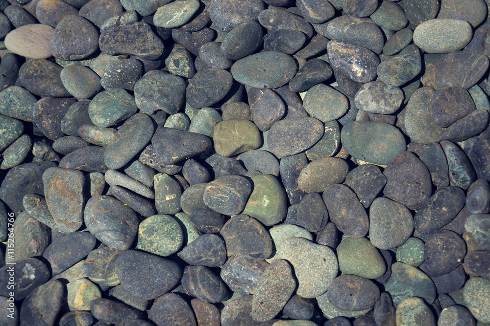 Grey stone pebbles under water lake bed background
