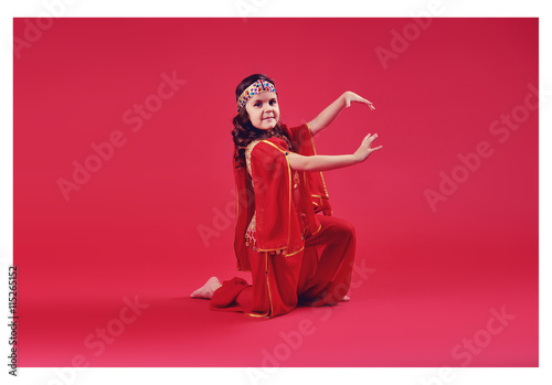 Close up shot of a belly dancer wearing a blue, gold and green costume shaking her hips. Isolated on white. Clipping path included so image can be easily transferred to a different colored background.