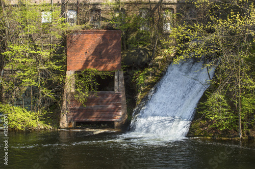 Water power sluice emerges from historic Dart's Stone Mill on the Hockanum River in Rockville, Connecticut. photo