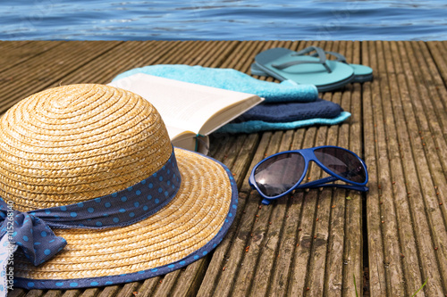 summer vacation, accessories for beach holidays on a wooden jetty at the pool