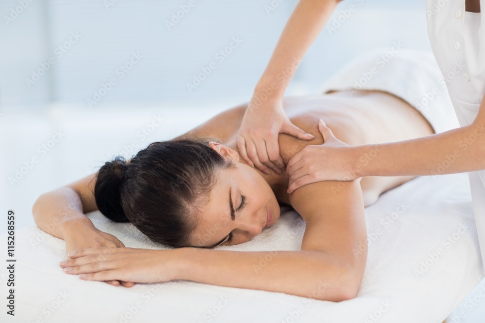 Relaxed naked woman receiving back massage Relaxed naked woman receiving back massage