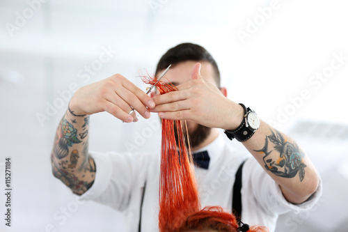Hairdresser cutting red curls