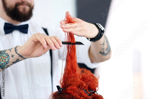 Hairdresser cutting red curls