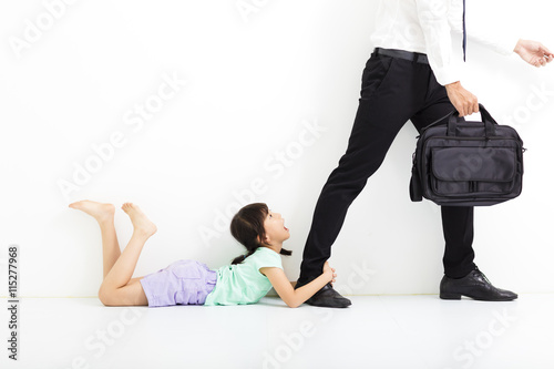 little girl holding her father's legs before go to work