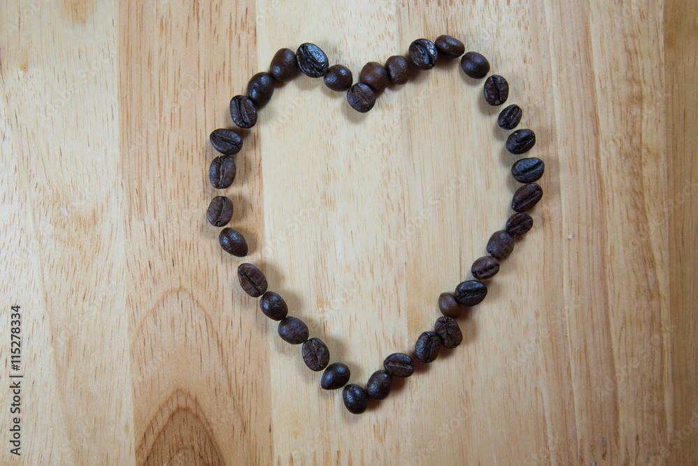 Coffee beans make into Heart shape on wood background Coffee beans make into Heart shape on wood background