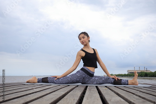 Thai woman professional yoga trainer poses in outdoor location in Thailand.