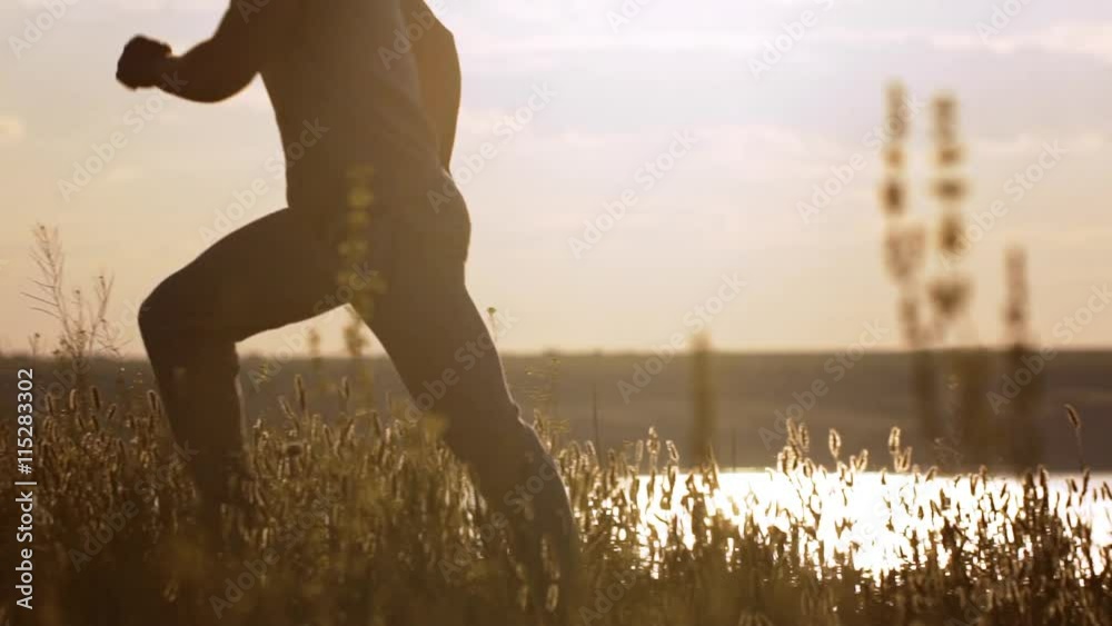 Silhouette of man jogging at sunset. Slow motion. Silhouette of man jogging at sunset. Slow motion.