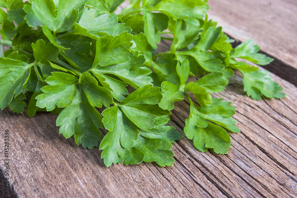 Green parsley lying on an old dark wooden surface. Green parsley lying on an old dark wooden surface.