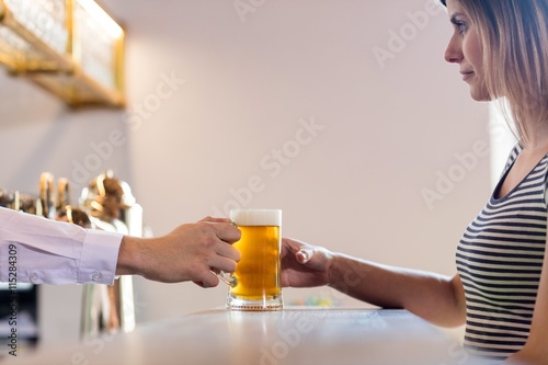 Bartender serving beer to female customer