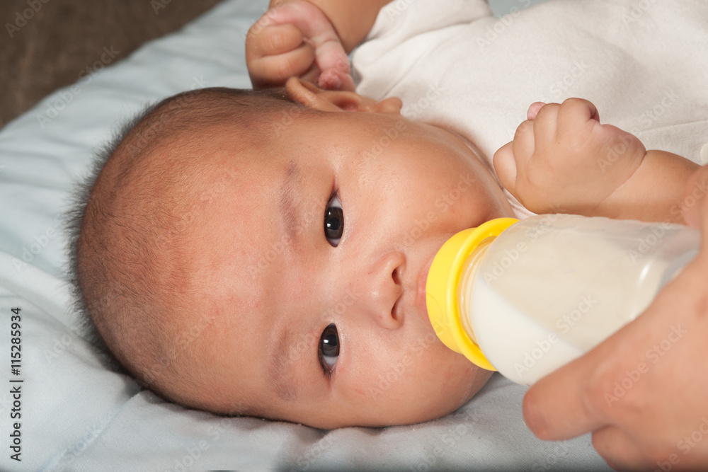 Asian newborn baby drinking milk from bottle. Asian newborn baby drinking milk from bottle.