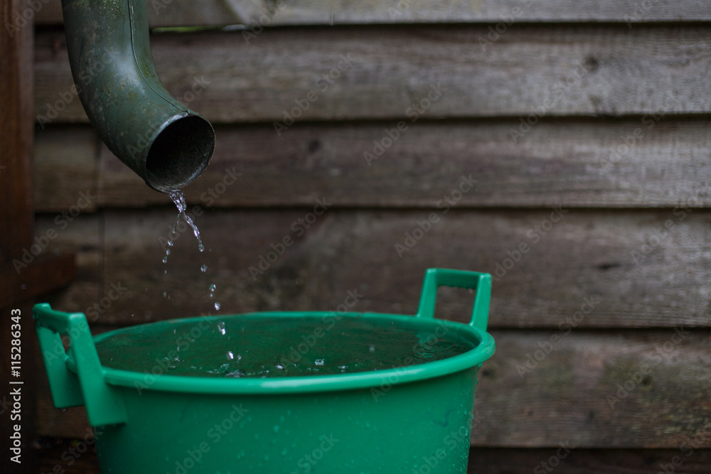 Rainwater shooting from a gutter into a water collecting reservoir Rainwater shooting from a gutter into a water collecting reservoir