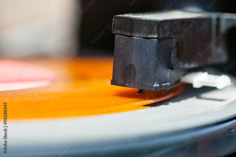 stylus of headshell on orange vinyl record stylus of headshell on orange vinyl record