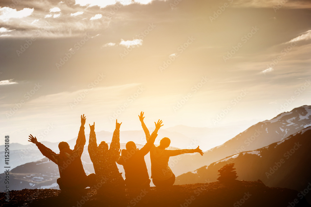 Group of friends sits on the top of mountain and having fun on mountains backdrop - obrazy, fototapety, plakaty 