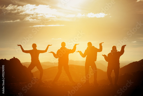 Group of happy friends having fun on sunset background