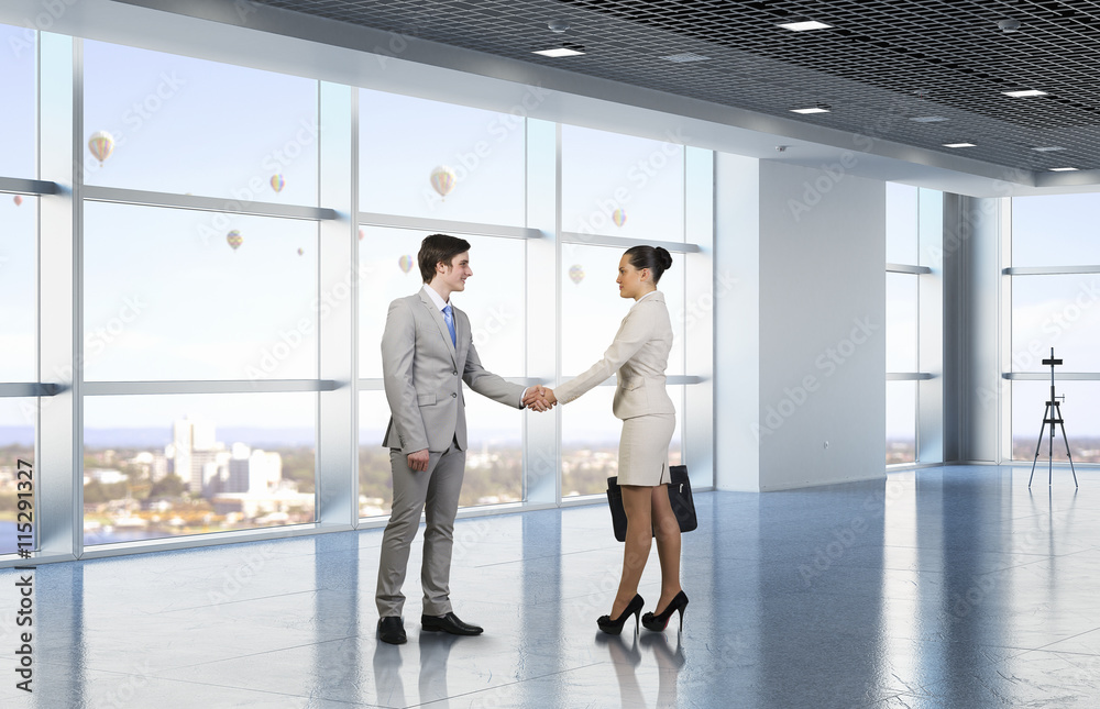 Two business partners shaking hands . Mixed media Two business partners shaking hands . Mixed media