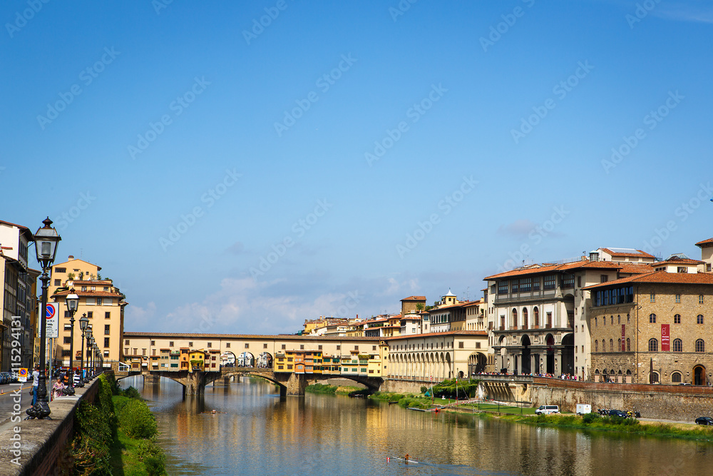 Fototapeta premium View of medieval stone bridge Ponte Vecchio and the Arno River from the Ponte Santa Trinita in Florence, Tuscany, Italy. Florence is a popular tourist destination.