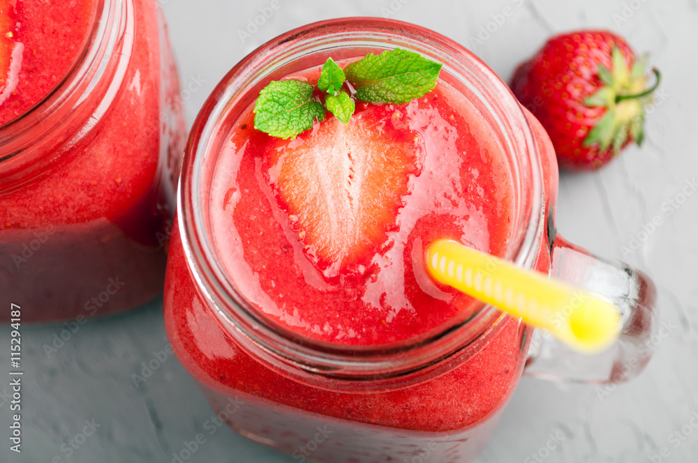 Strawberry smoothies in glass jar and strawberry on stone background closeup. Healthy summer drink Strawberry smoothies in glass jar and strawberry on stone background closeup. Healthy summer drink