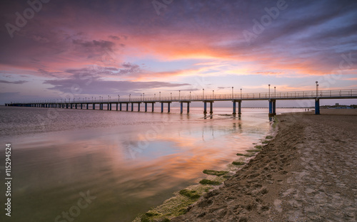 Sunset on the beach after a storm, the pier and the in the evening © Igor Sobolev