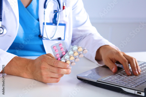 the doctor writes a prescription pill on the computer