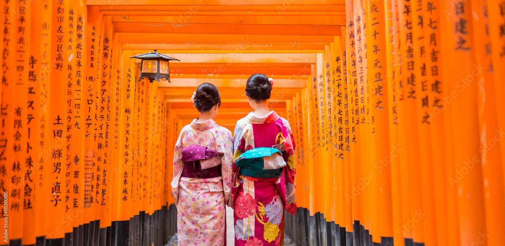 Φωτογραφία Two geishas among red wooden Tori Gate at Fushimi Inari Shrine in Kyoto, Japan
