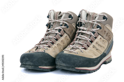 Old scuffed hiking boots on white background