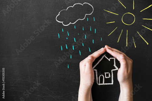hands protects a house from the elements - rain or storm
