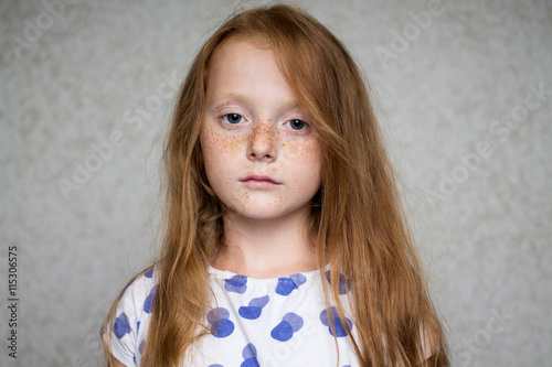 Close up portrait of a pensive ginger girl with freckles