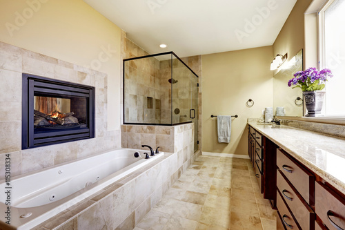 Master bathroom in modern house with fireplace and tile floor