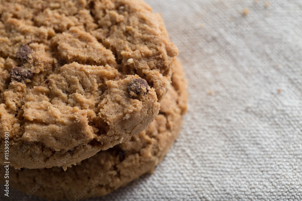 Cookies pile with chocolate chip on light textile background. Delicious morning snacks for breakfast, brunch and lunch. Appetizing, healthy, sweet, scrummy, and fast food. Cookies pile with chocolate chip on light textile background. Delicious morning snacks for breakfast, brunch and lunch. Appetizing, healthy, sweet, scrummy, and fast food.