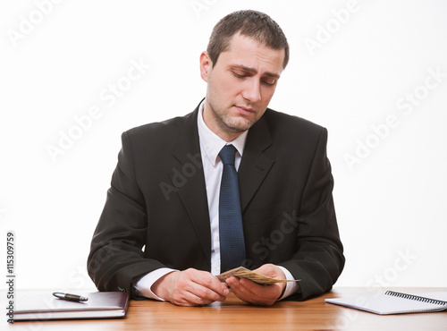 Businessman counting  dollar's banknote with tragic expression photo